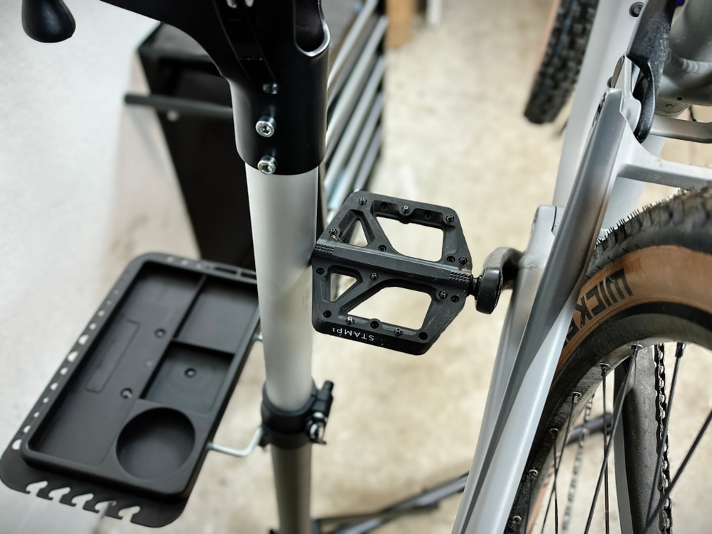 Ein Pedal stößt an den Fahrrad-Montageständer.