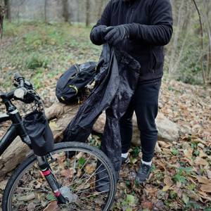 Die Fahrrad-Regenhose von Asfixiado wird im Wald über einer anderen Hose anprobiert.