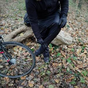 Die Fahrrad-Regenhose von Asfixiado wird im Wald über einer anderen Hose anprobiert.