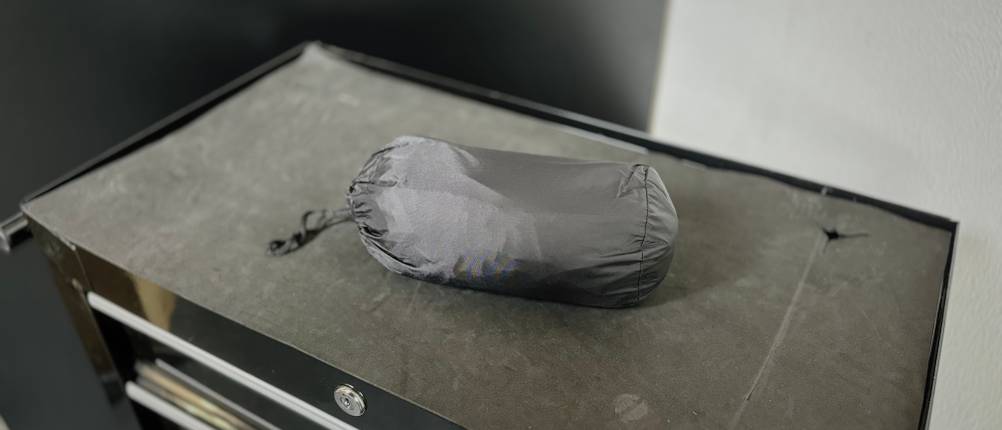 Die Fahrrad-Regenhose von Asfixiado liegt in ihrem Beutel auf einem Rollwagen.