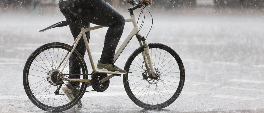 Seitenansicht eines Radfahrers bei Regen.
