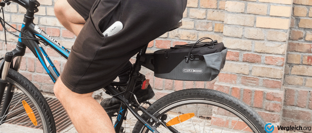 Eine große Fahrrad-Satteltasche ist an einem Fahrrad befestigt. Eine Person fährt mit dem Fahrrad.