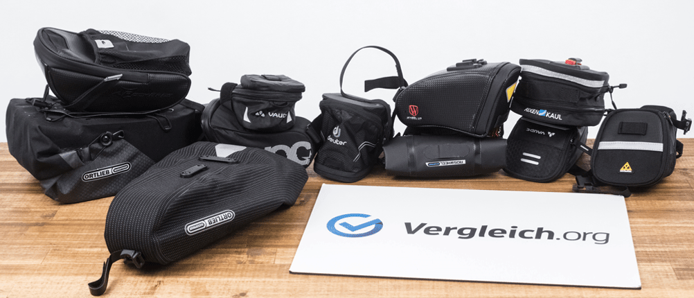 Mehrere Fahrrad-Satteltaschen liegen für einen Test auf einem Tisch.