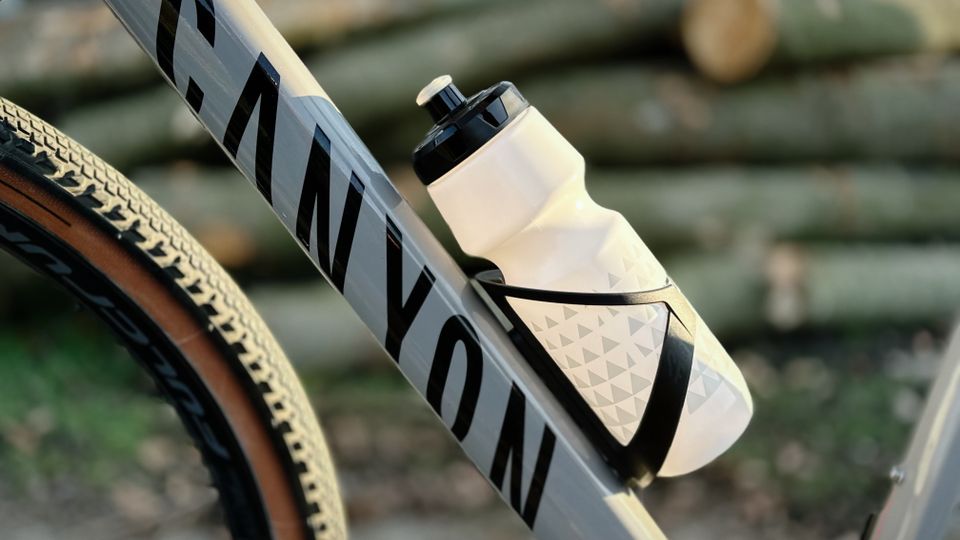 Die GEMFUL GF001 Trinkflasche sitzt in einem schwarzen Flaschenhalter an einem Canyon Gravelbike. Der matte Rahmen und das Design der Flasche harmonieren optisch.