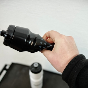 Eine Hand hält die GEMFUL GF001 Trinkflasche und drückt sie leicht zusammen. Das flexible Material ermöglicht eine einfache Handhabung beim Trinken.