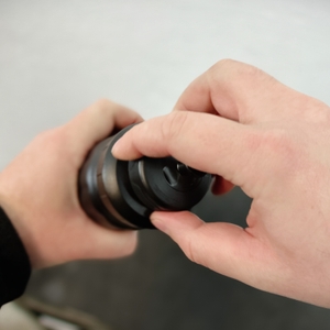 Eine Hand schraubt den Deckel der SIGG WMB Sports Trinkflasche ab. Das große Gewinde sorgt für einen sicheren Verschluss.