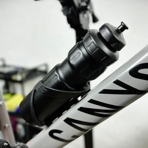 Die SIGG WMB Sports Trinkflasche steckt in einem Fahrradflaschenhalter an einem Canyon-Rad. Das schlichte Design passt gut zum Rahmen.