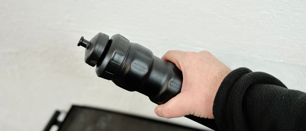 Eine Hand hält die SIGG WMB Sports Trinkflasche, die durch ihr festes Aluminiumgehäuse nicht zusammengedrückt werden kann.