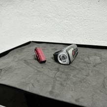 Das Sigma Sport Aura 80 Blaze Set mit Front- und Rückleuchte liegt auf einer dunklen Oberfläche. Die kompakte Bauweise der Beleuchtung ist deutlich erkennbar.