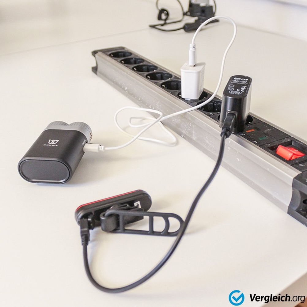 Fahrradbeleuchtung im Test: Fahrradlampen, die per USB-Kabel an einer Mehrfachsteckdose angeschlossen sind