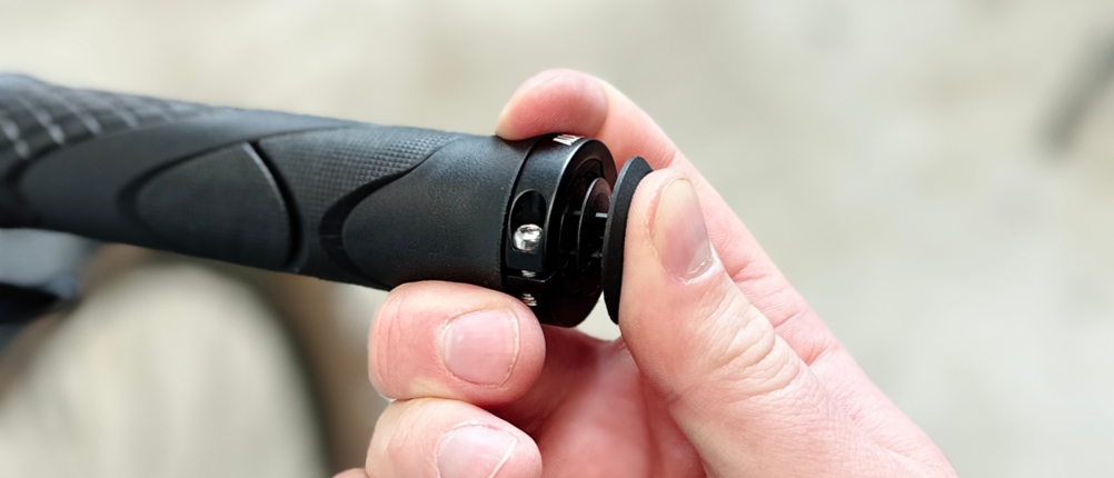 Ein Fahrradgriff von Alphatrail wird mit einem Schraubendreher an der Außenseite fixiert. Der Lenker ist nur teilweise sichtbar.