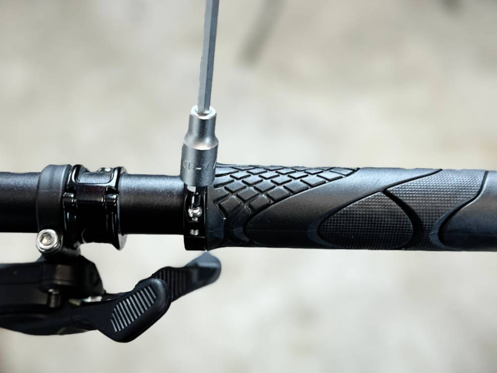 Ein Fahrradgriff von Alphatrail wird gerade am Lenker ausgerichtet. Die Klemmschraube ist bereits leicht angezogen.