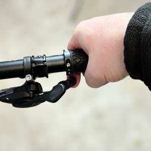 Ein montierter Alphatrail-Fahrradgriff wird mit der Hand umfasst. Die Schaltung ist nah am Griff positioniert.