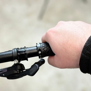 Eine Hand umgreift den montierten Alphatrail-Fahrradgriff am Lenker. Die Griffstruktur ist gut zu erkennen.