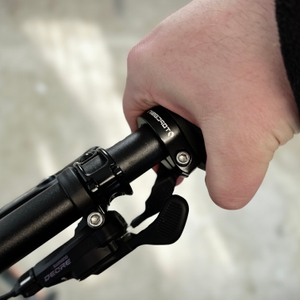 Eine Hand umgreift den montierten Fahrradgriff von Topcabin. Der Griff ist am Lenker eines Fahrrads befestigt.