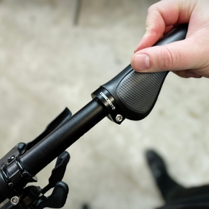 Ein Topcabin-Fahrradgriff wird auf den Lenker aufgeschoben. Die Hand führt den Griff vorsichtig in Position.