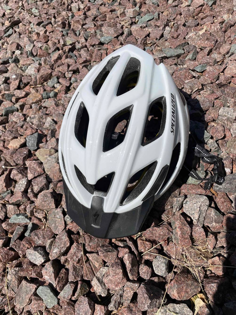 Fahrradhelm-Herren-Test: Ein Fahrradhelm liegt auf einem steinigen Untergrund.