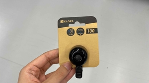 Schwarze Fahrradklingel mit 75 dB in ihrer Verpackung. 