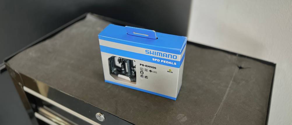 Die Verpackung der Shimano Fahrradpedale steht auf einem Rollwagen.
