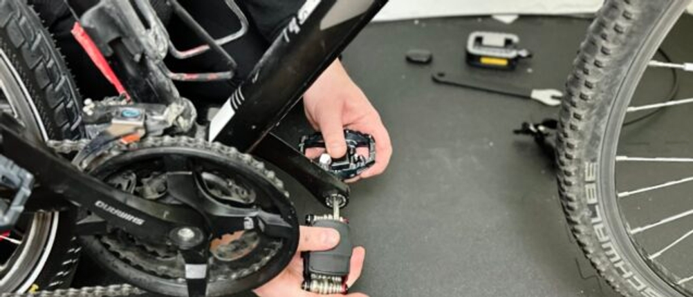 Das Fahrradpedal von Shimano wird an ein Fahrrad montiert.