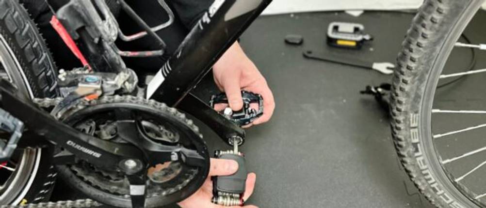 Das Fahrradpedal von Shimano wird an ein Fahrrad montiert.