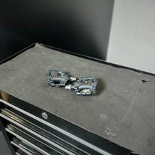 Die Fahrradpedale von Shimano liegen auf einem Rollwagen.