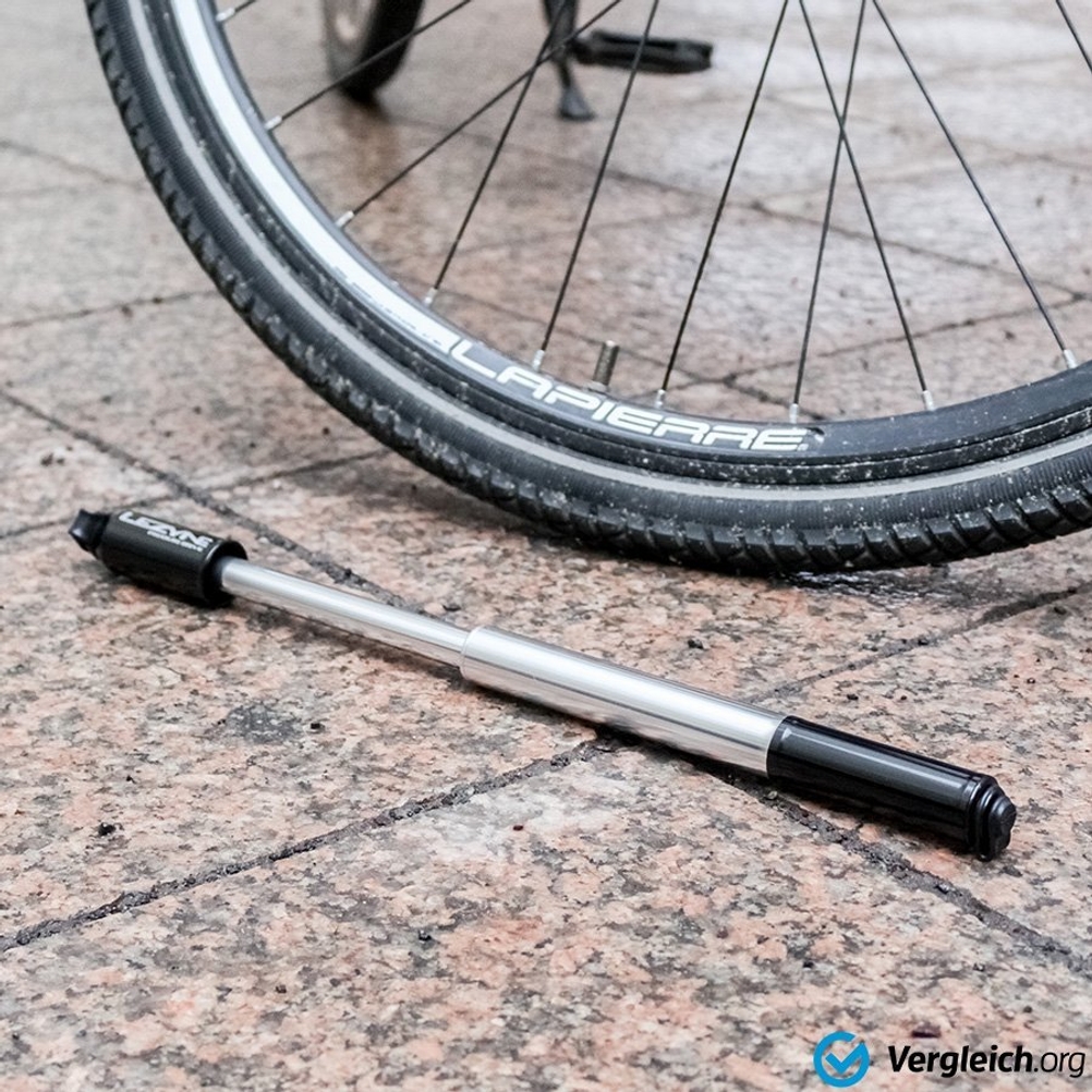 Fahrradpumpen-Test: Eine Handpumpe liegt neben einem Fahrradreifen. 