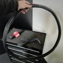 Der Fahrradreifen von Fincci wird in der Hand gehalten. Im Hintergrund liegt das Zubehör auf einem Rollwagen.