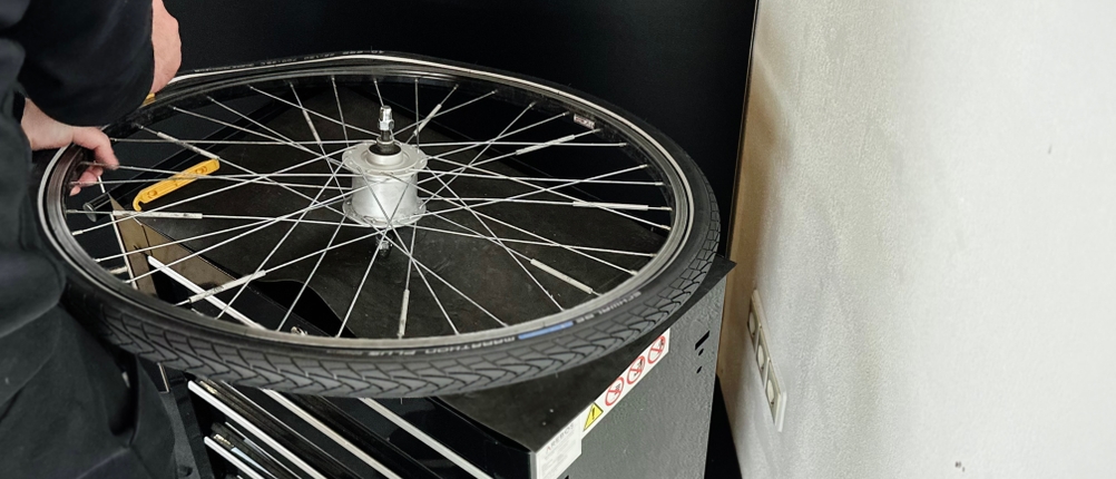 Der Fahrradreifen von Schwalbe wird auf ein Rad eines Fahrrads montiert.