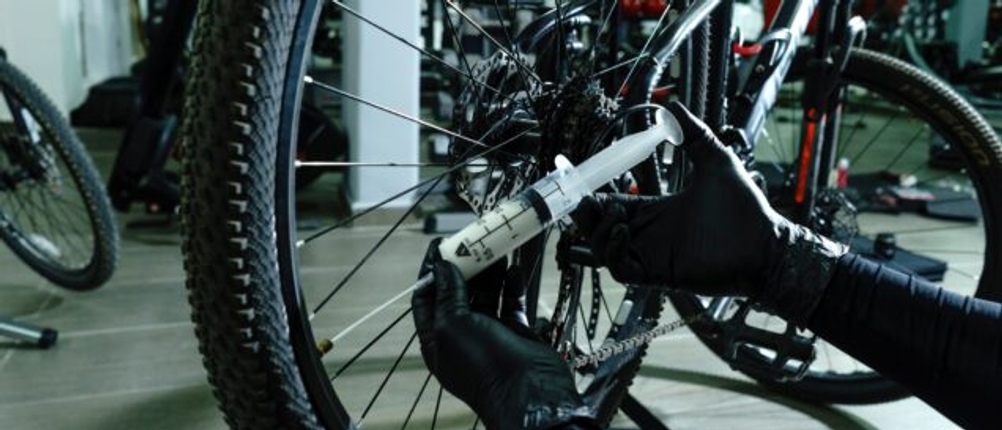 Dichtmilch wird in einen Tubeless-Reifen gespritzt.