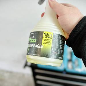 Die Nahaufnahme zeigt das Etikett des Dr.-Wack-F100-Fahrradreinigers mit dem Hinweis auf die neue Formel. Die Flasche wird in der Hand gehalten.
