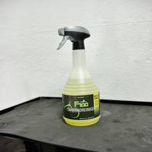 Die Flasche des Dr. Wack F100 Fahrradreinigers steht auf einem schwarzen Werkstattwagen vor weißer Wand. Die Etikettierung ist vollständig sichtbar.