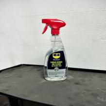 Die Flasche des WD-40 Bike Reinigers steht auf einer dunklen Werkbank. Der rote Sprühkopf ist montiert, das Etikett zeigt die Produktbezeichnung.