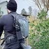 Ein Radfahrer hat einen Fahrradrucksack von Deuter auf dem Rücken. Eine schwarze Flasche steckt in der Seitentasche des Rucksacks.