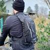 Der Toptrek Fahrradrucksack wird auf dem Rücken eines Radfahrers getragen. Die Rückseite des Rucksacks zeigt reflektierende Elemente und die Marke.