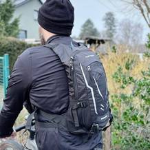 Der Toptrek Fahrradrucksack wird auf dem Rücken eines Radfahrers getragen. Die Rückseite des Rucksacks zeigt reflektierende Elemente und die Marke.