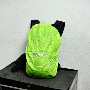 Der Toptrek-Fahrradrucksack ist mit einer leuchtgrünen Regenhülle abgedeckt. Die Hülle trägt das Markenlogo und liegt eng am Rucksack an.