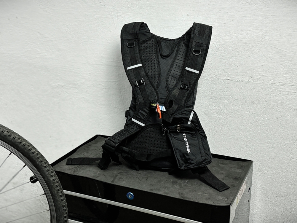 Die Rückseite des Toptrek-Fahrradrucksacks ist vollständig zu sehen. Das Tragesystem zeigt atmungsaktive Polsterung und breite Gurte.