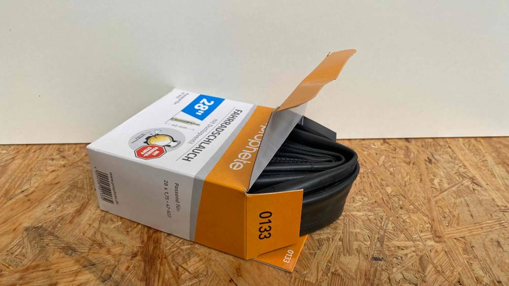 Fahrradschlauch für 28-Zoll große Fahrräder: Geöffnete Verpackung von einem Fahrradschlauch für 28-Zoll große Fahrräder. 