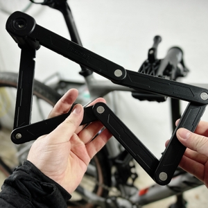 Eine Person hält das aufgeklappte Fischer-Faltschloss in beiden Händen. Die einzelnen Segmente sind miteinander verbunden.