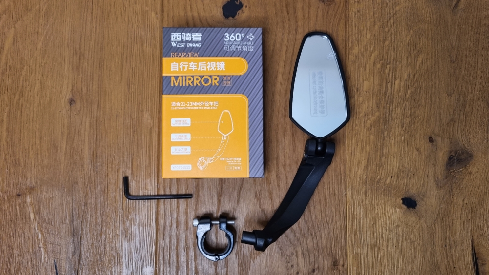Chimona-Fahrrad-Spiegel liegt neben der Verpackung mit Montagematerial auf einem Tisch.