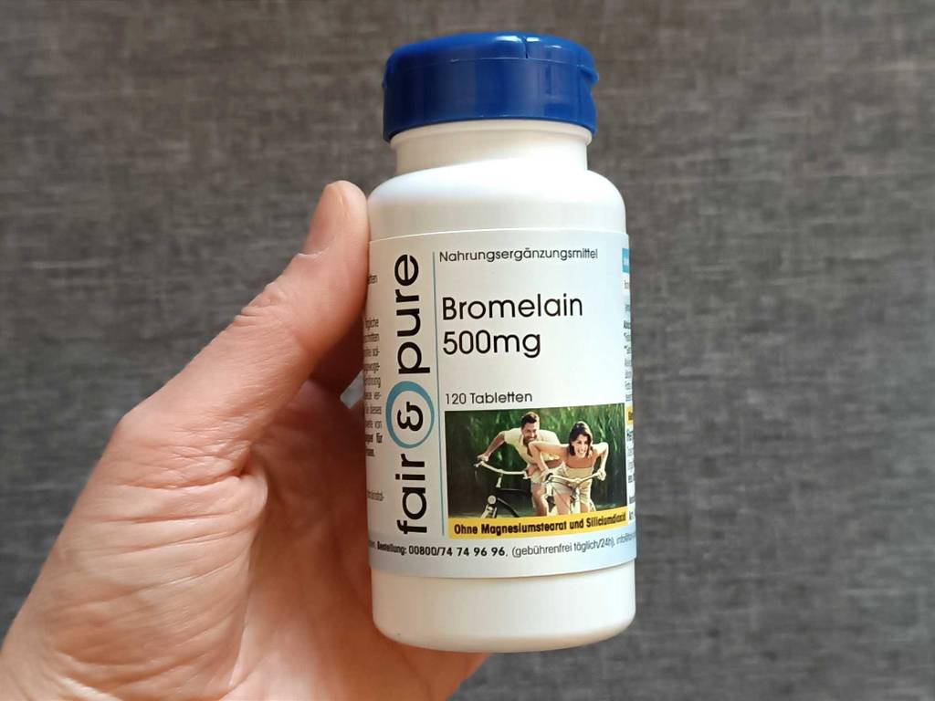 Eine Kunststoffdose mit 120 Tabletten Nahrungsergänzungsmittel im Test (Bromelain 500 mg) in einer Hand.