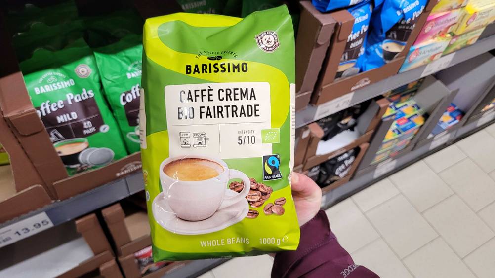 Eine Hand hält eine Packung der getesteten Fairtrade-Kaffeebohnen hoch.