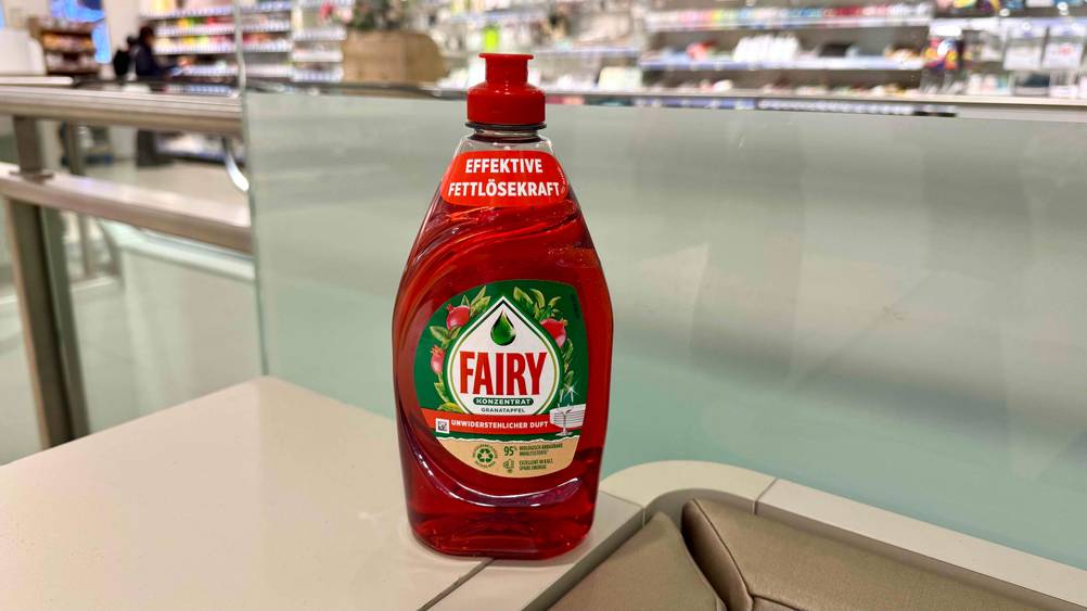 Vor einer Glaswand steht eine Flasche des Fairy-Spülmittels im Test.