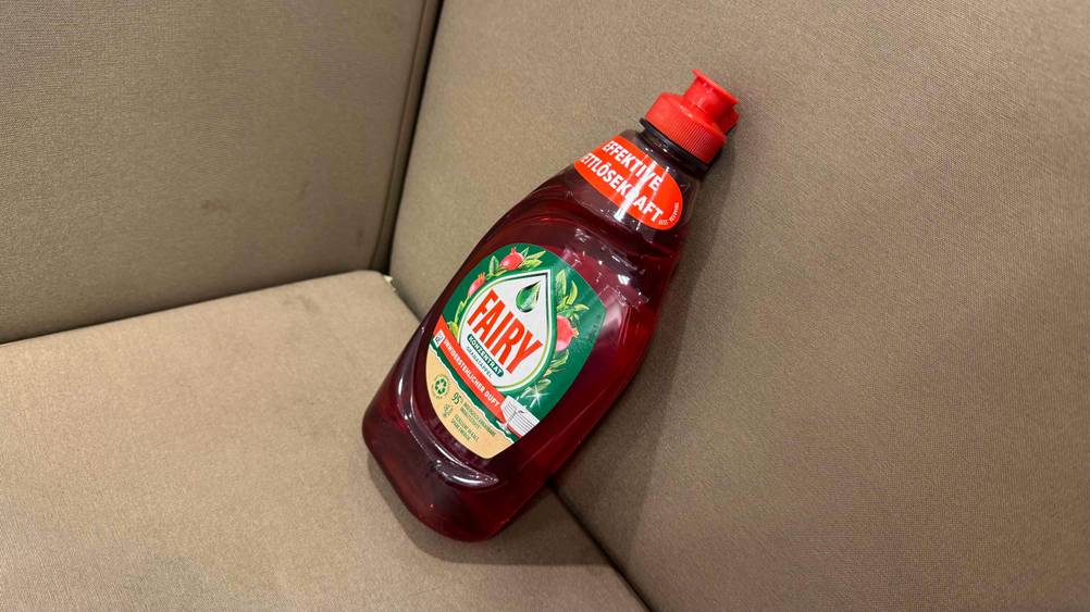 Fairy-Spülmittel im Test: Eine Flasche leicht seitlich auf einem beigen Polster.
