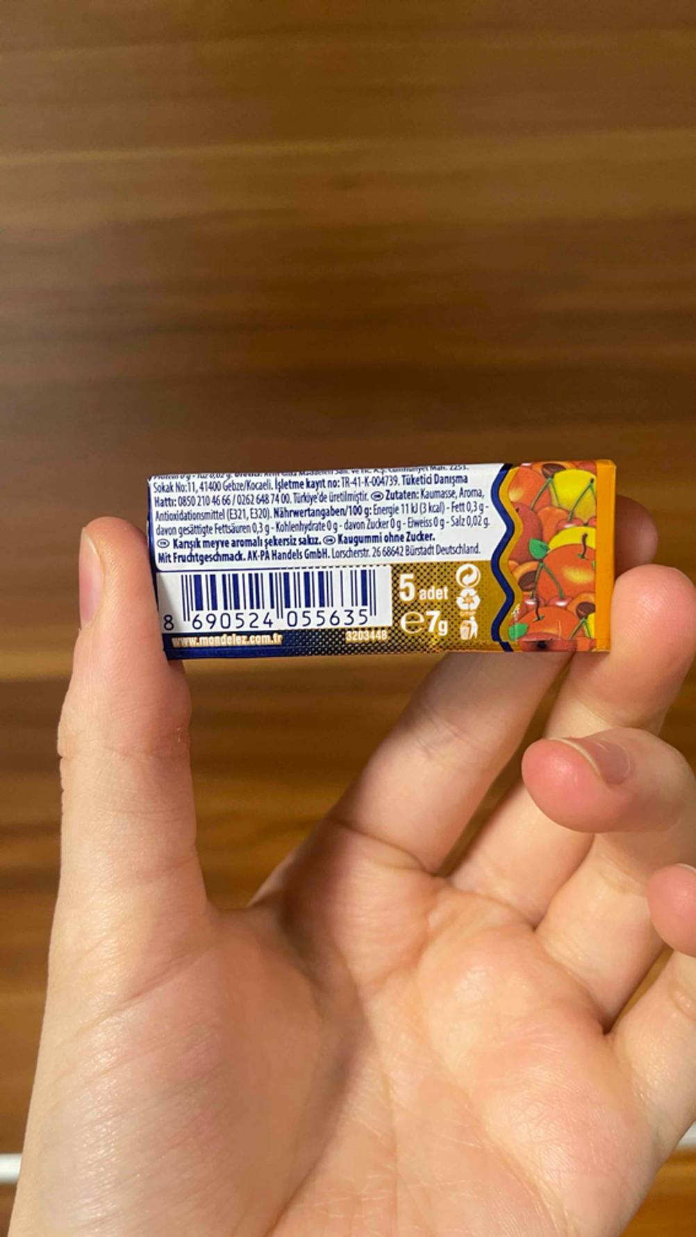 Eine Hand hält eine Packung des Falim-Kaugummis im Test mit der Rückseite nach vorne.