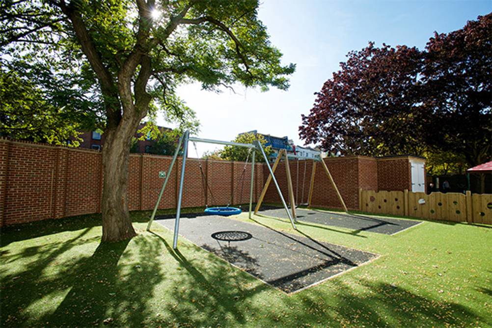 Fallschutzmatten im Test: Ein Schaukelbereich im Garten der mit Fallschutzmatten ausgestattet ist.