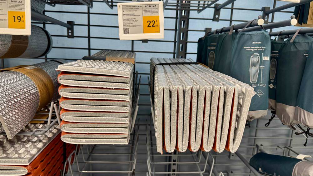 Im Verkaufsregal liegen mehrere der getesteten faltbaren Isomatten neben anderen Produkten.