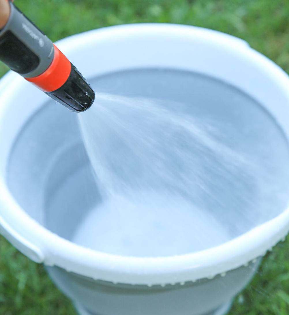 Falteimer-Test: Ein getesteter Falteimer wird mit einem Gartenschlauch gereinigt.