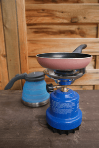 Faltbare Wasserkocher im Test: Auf einem Gaskocher steht eine kleine Pfanne und daneben steht ein Camping-Wasserkocher.